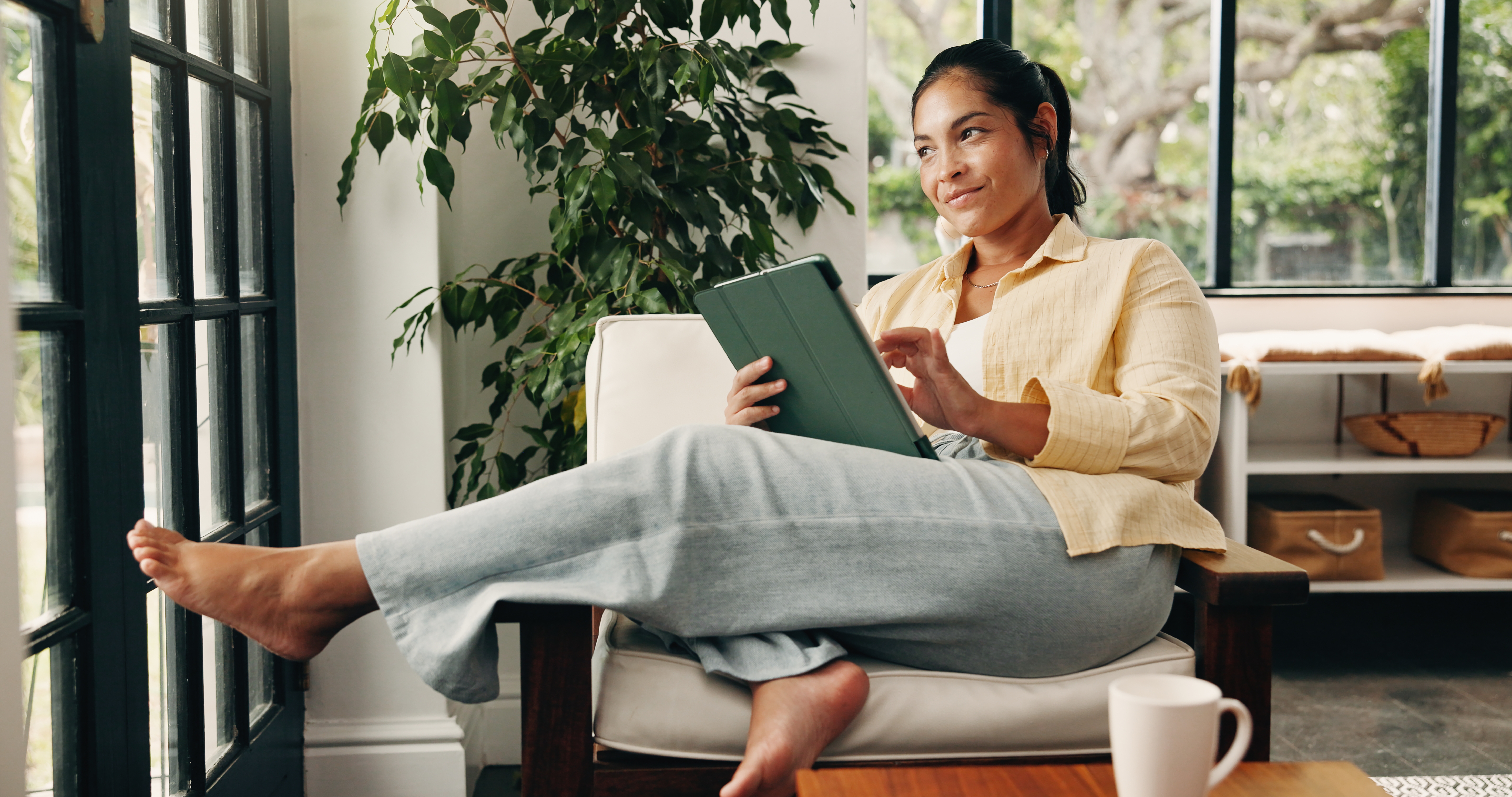 Woman relaxing at home reading on a tablet Woman relaxing at home reading on a tablet