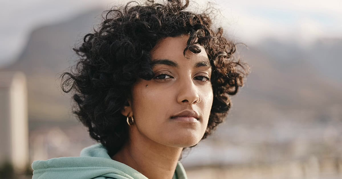 young-black-woman-outdoors-looking-confidently-at-camera Young black woman outdoors looking confidently at camera
