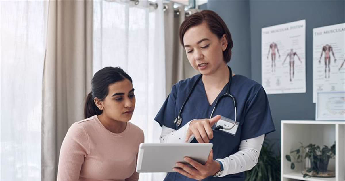 physician showing material on a tablet to patient Confident young woman looking at camera