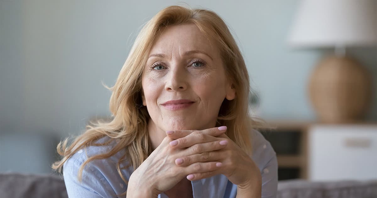 Confident woman in her 50s gazing at camera
